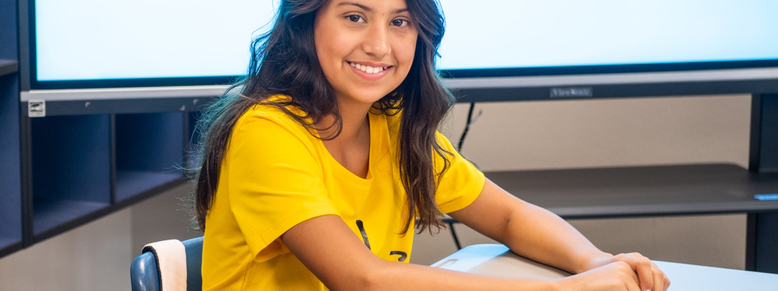 student at desk smiling