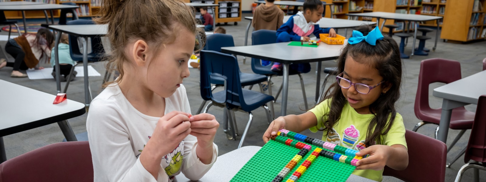 two girls playing with Lego bricks