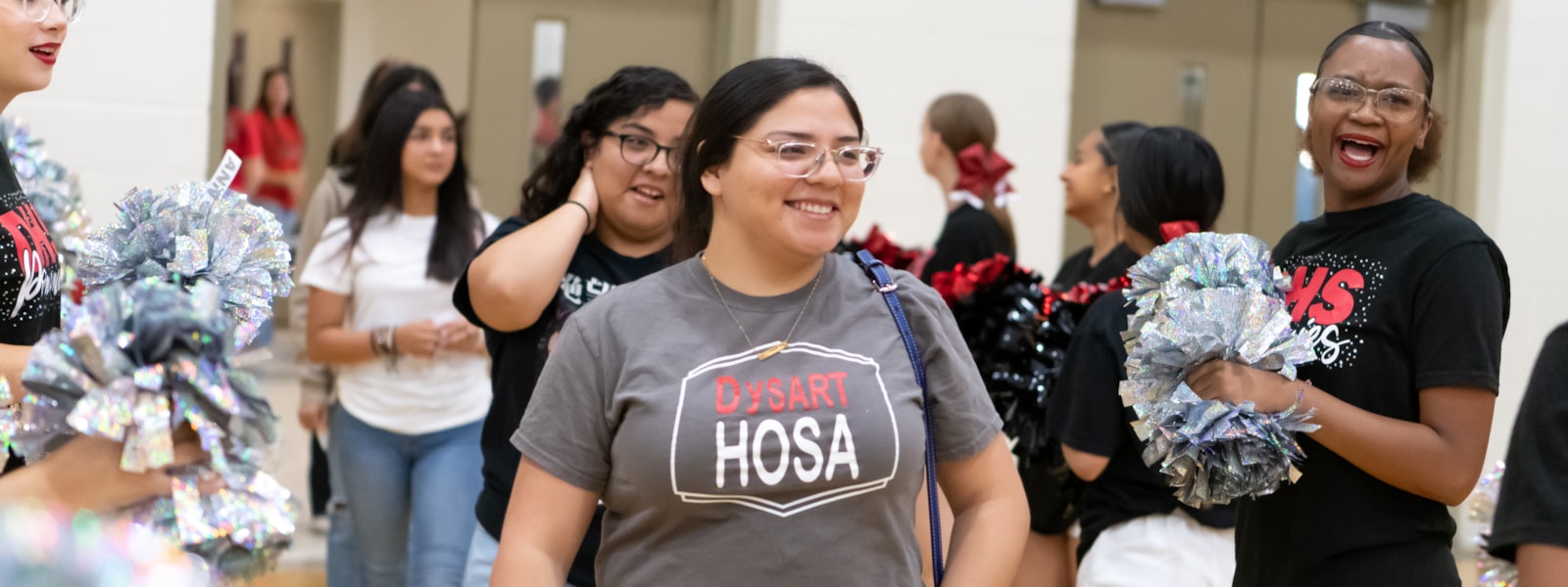HOSA member walking past cheerleaders
