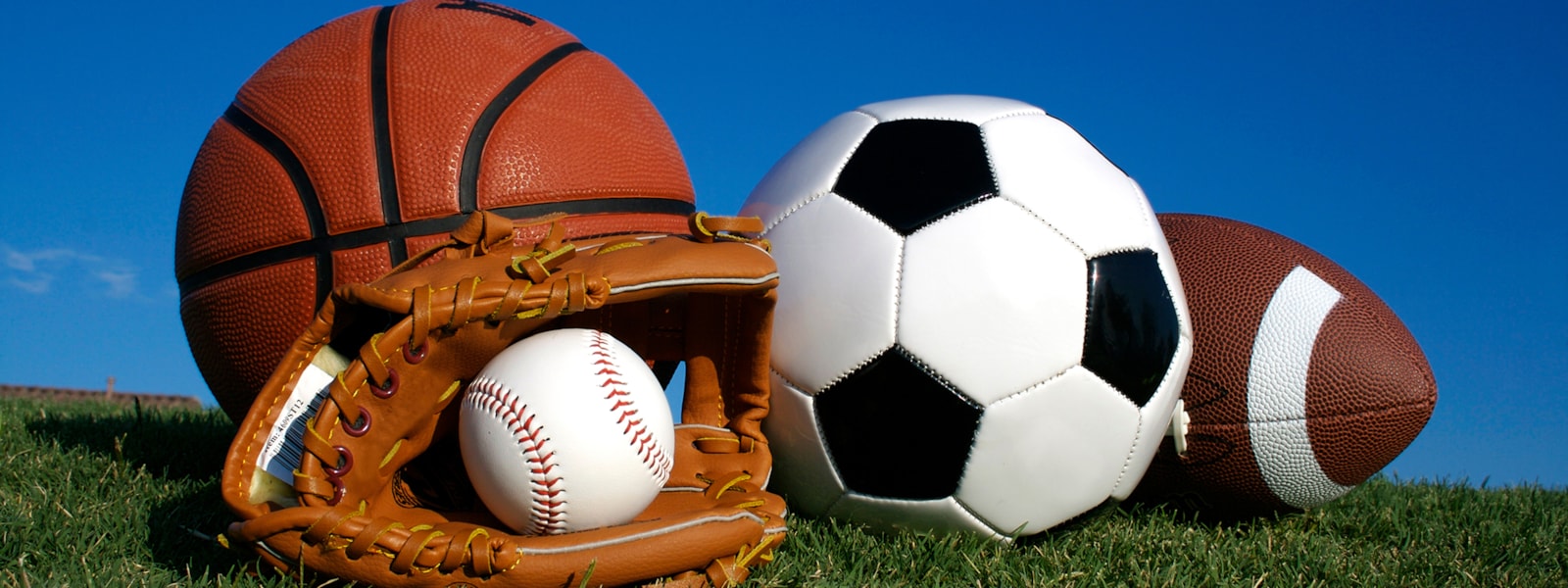 Picture of basketball, baseball with glove, soccer ball, and football