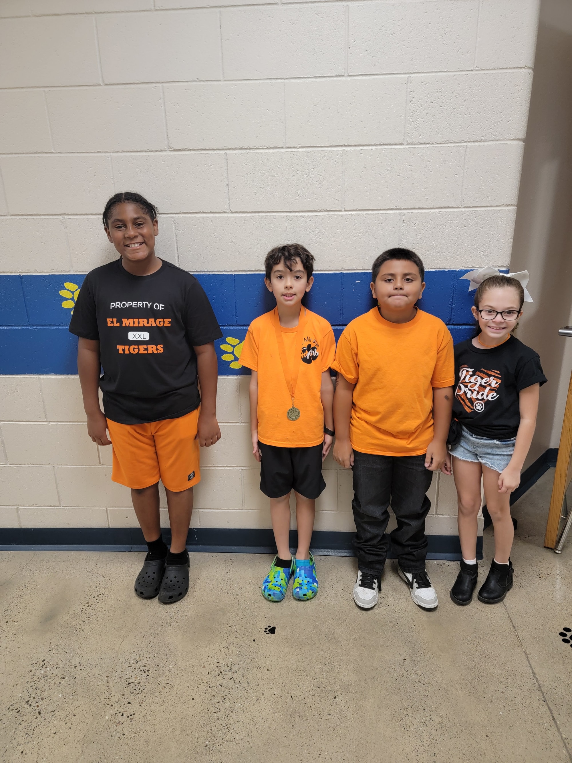 Four students dressed in orange and black.