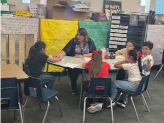 Mrs. Blanco working with students in the library.