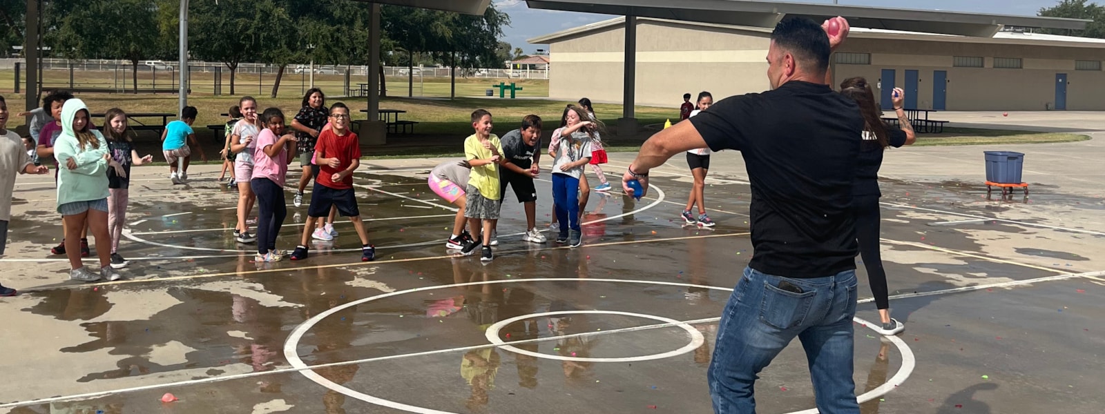 Assistant Principal throwing water balloons with 3rd grade class.