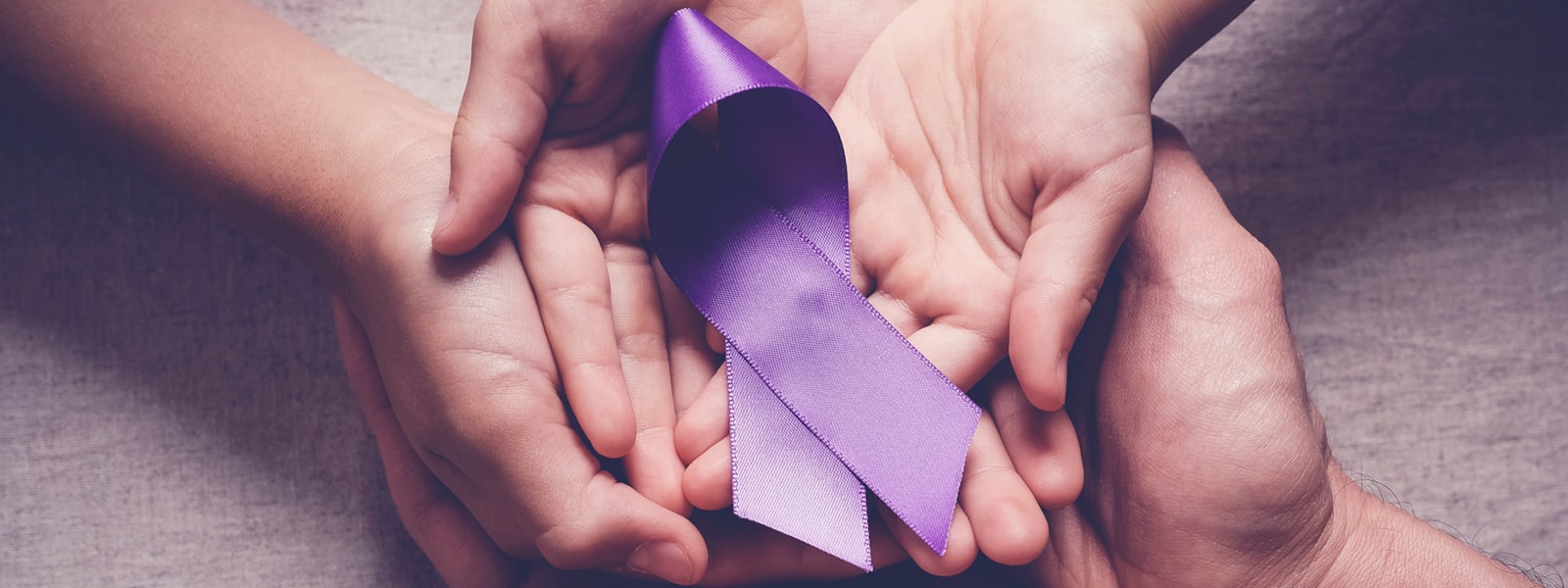 hands holding purple ribbon