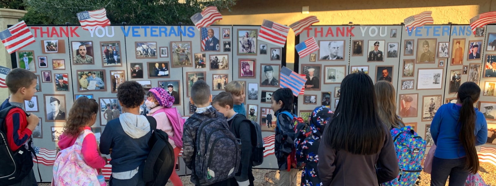 students looking at veteran pictures