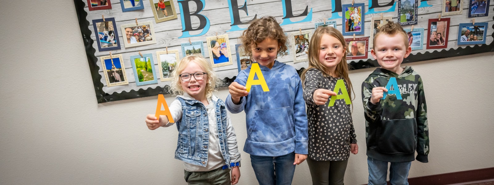 Students holding little A cut outs.