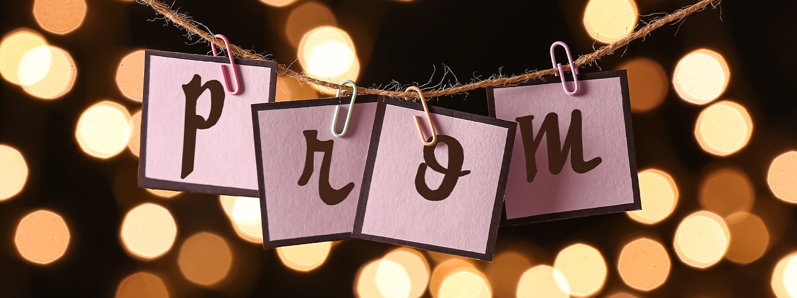 The word PROM spelled out on card stock and hung from a clothesline