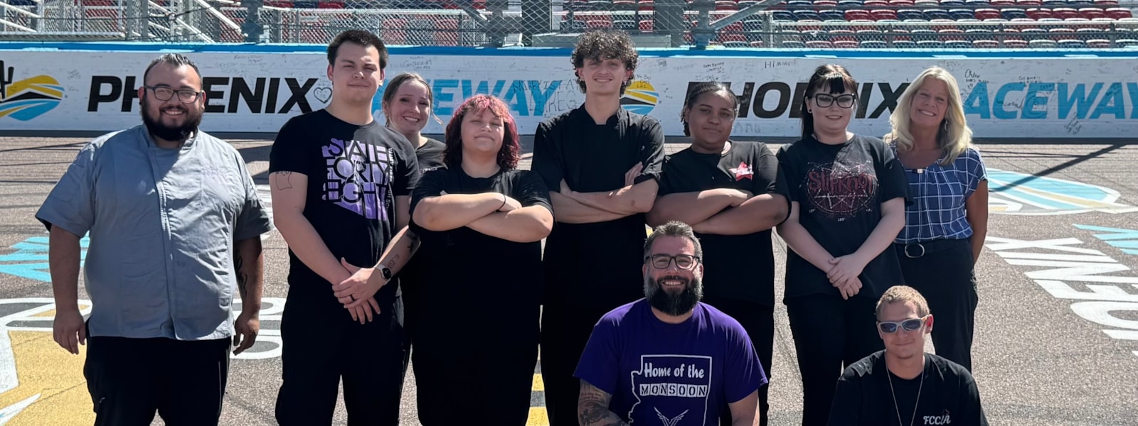 students and staff posing at racetrack
