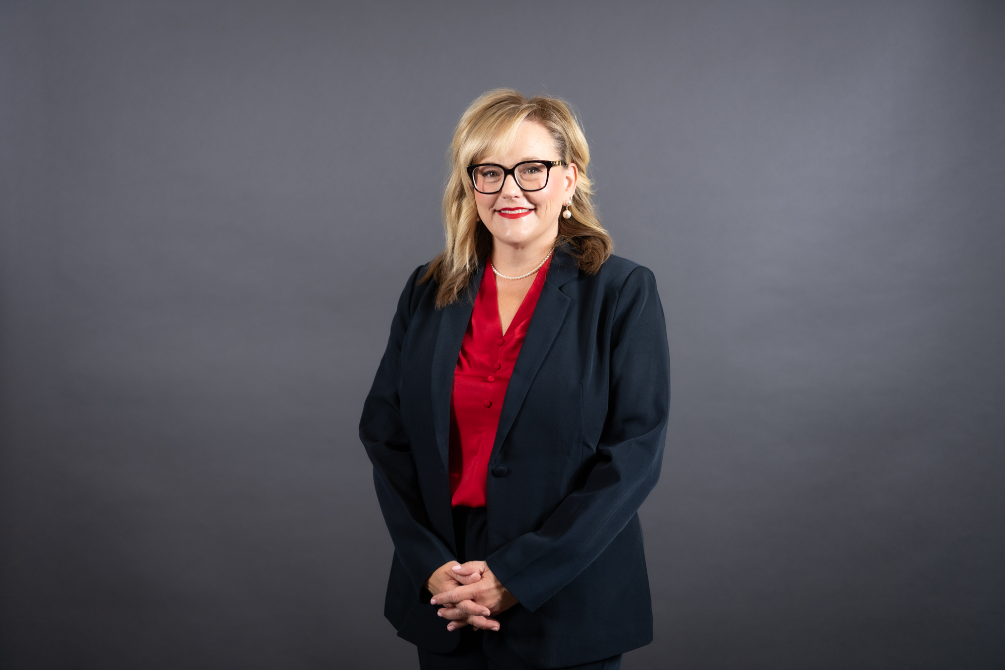 Amy Lundberg with red blouse and black suit jacket and pants